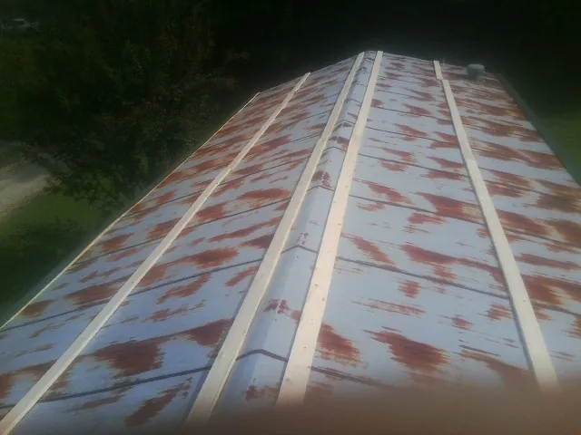 Rusted metal roof panels with new wood purlins before replacement — Storm Damage Roof Repair in Depew by Roofing Brothers